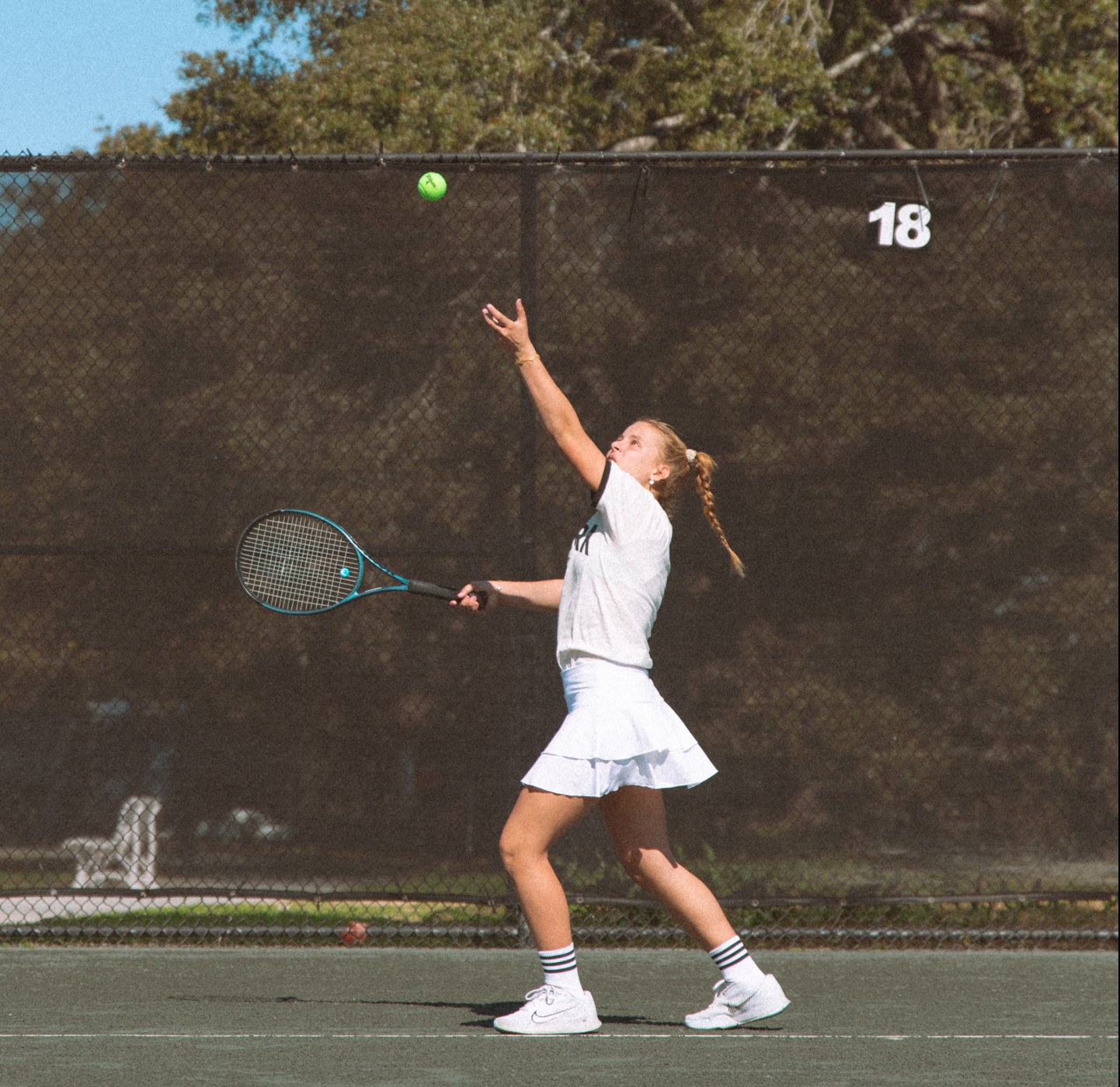 Young tennis player serving on an outdoor court